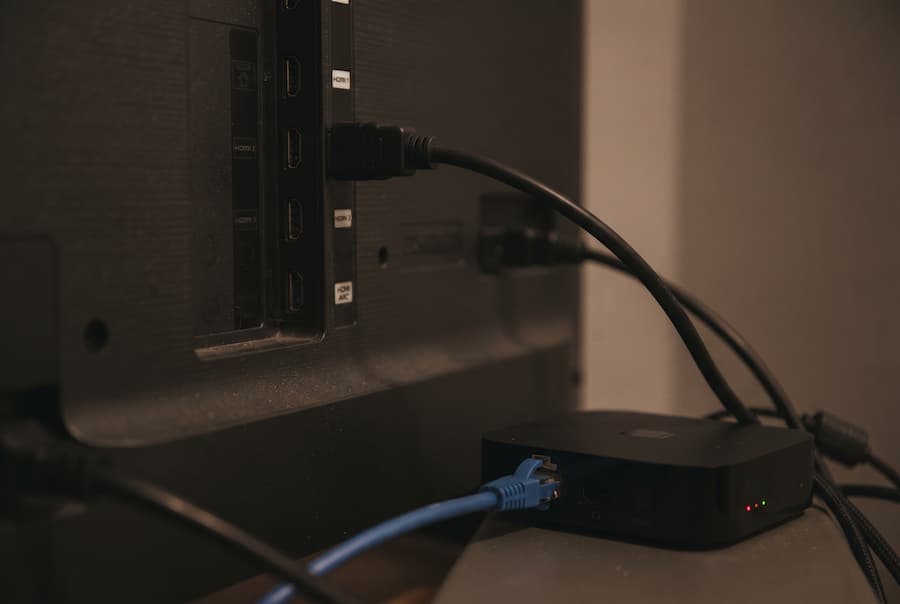 Πίσω μέρος τηλεόρασης με καλώδιο HDMI και καλώδιο Ethernet συνδεδεμένα σε TV Box
